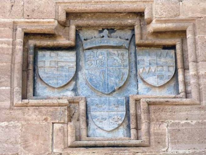 В центре геральдической композиции - четверочастный щит короля Иерусалима, Кипра и Армении Жана II Люзиньяна (1432 - 1458) с гербом армянского титула в 3-м поле. Замок Колосси, Кипр